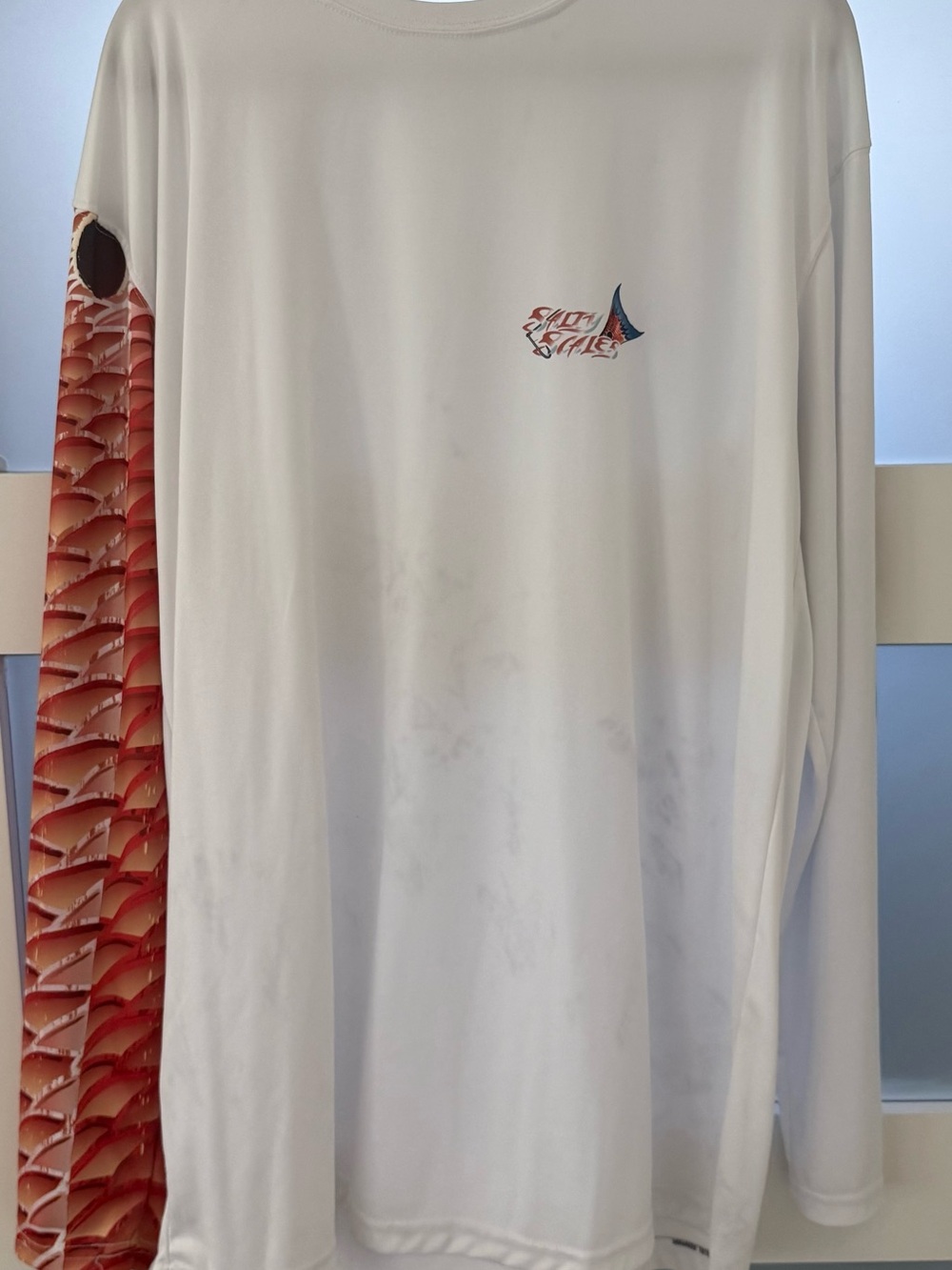 Fishing shirt. Red fish scales down the arm.